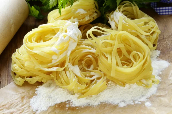 自制面条 (pasta) 木制的桌子上 — 图库照片