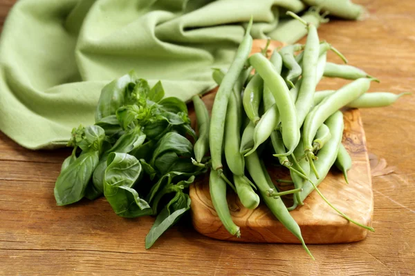 Verse groene bonen op een houten tafel — Stockfoto