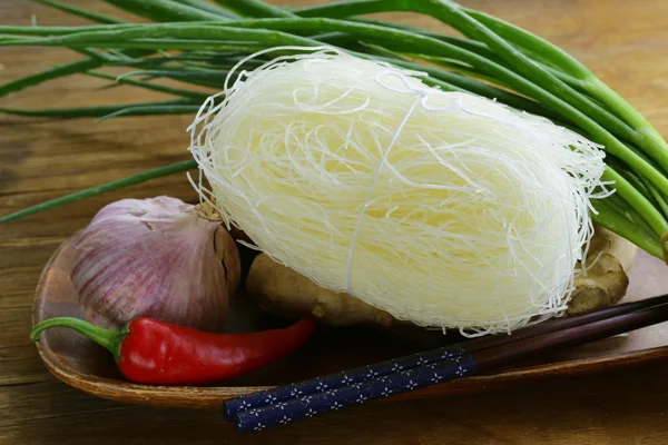 Asian food ingredients - rice noodles, ginger, chili pepper, garlic — Stock Photo, Image