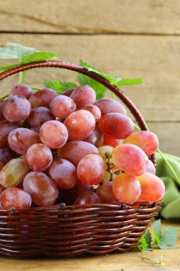 ahşap bir masa üzerinde bir sepet içinde kırmızı olgun organik üzüm