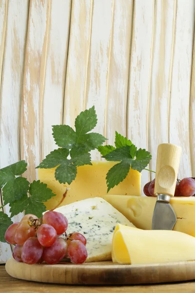 Sýrový nářez (maasdam, roquefort, camembert) a hrozny, dezert — Stock fotografie