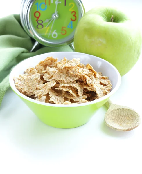Zdrowe śniadanie - musli i jabłko (budzik w tle) — Zdjęcie stockowe