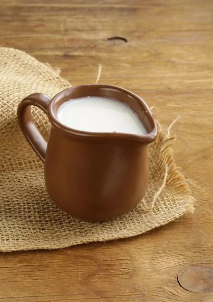 Jarra de cerámica marrón llena de leche, estilo rústico —  Fotos de Stock