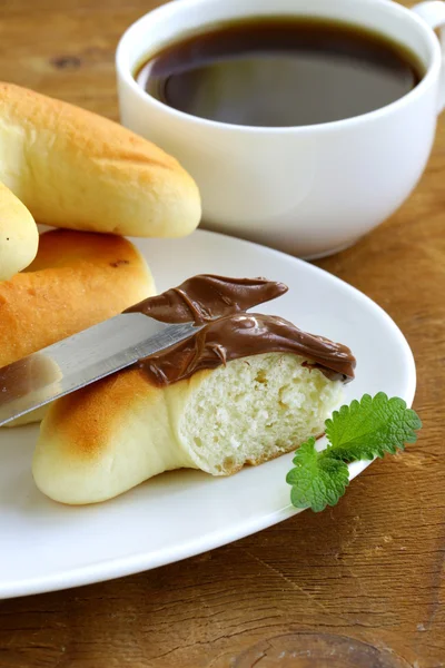 Čokoláda oříšková pasta (nutella) k snídani s rohlíky — Stock fotografie