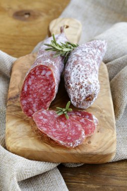 Bir kesme tahtası üzerinde füme incelik sosis (biber)