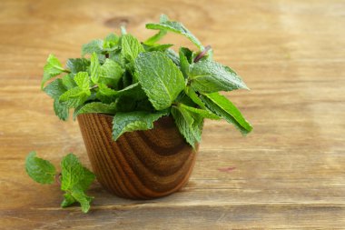 ahşap kesme tahtası üzerinde taze yeşil nane demet
