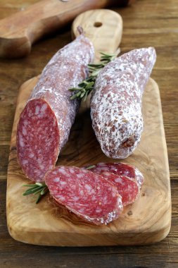 Bir kesme tahtası üzerinde füme incelik sosis (biber)