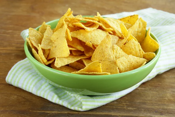 Patatas de maíz (nachos) en un tazón verde sobre mesa de madera — Foto de Stock