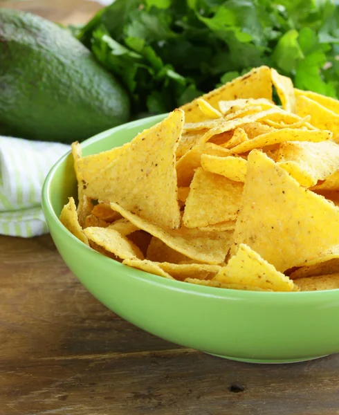 Majschips (nachos) i en grön skål på träbord — Stockfoto