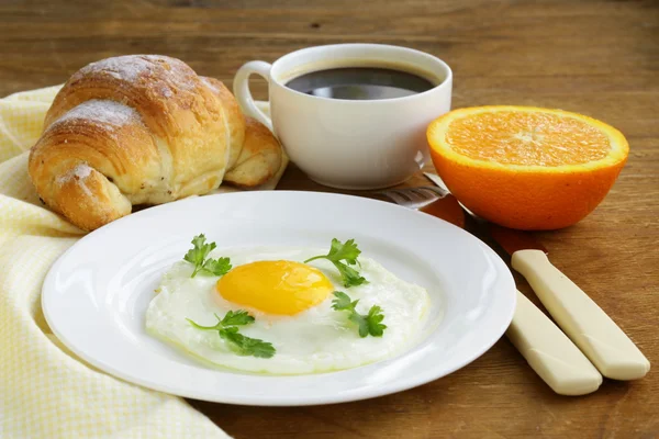 Continental breakfast - croissant, fried egg, toast and oranges — Stock Photo, Image