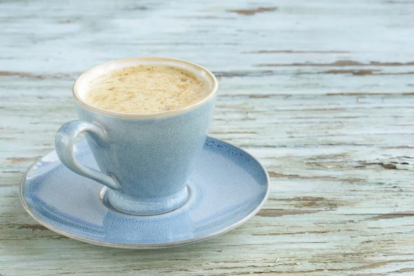 Modrá šálek cappuccina na vinobraní dřevěné pozadí — Stock fotografie