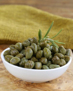 ahşap masa üzerinde beyaz kase salamura Kapari