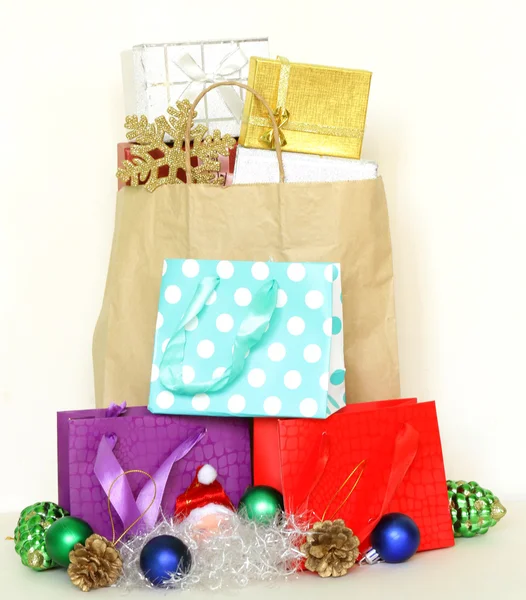 Pek çok hediye kutuları ve beyaz arka plan üzerinde renkli alışveriş torbaları — Stok fotoğraf