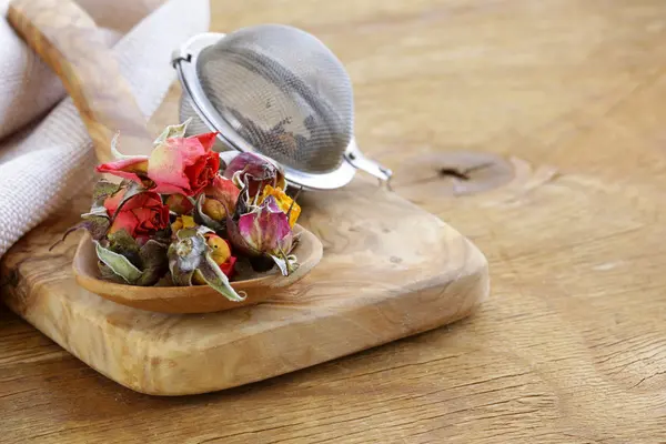 Kruiden thee uit de gedroogde bloemknoppen van rozen in een houten lepel — Stockfoto