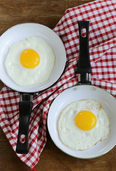 Duas panelas com ovos fritos - café da manhã de pares — Fotografia de Stock