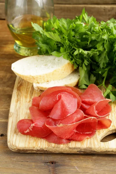 Smoked meat bresaola on a cutting board — Stock Photo, Image