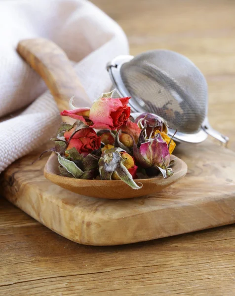 Травяной чай из сушеных цветков бутонов роз в деревянной ложке — стоковое фото