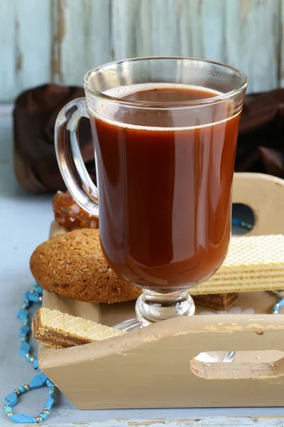 Hot cocoa in a glass on wooden table — Stock Photo, Image