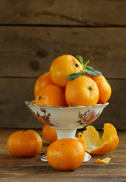 Fresh ripe orange mandarins (tangerines) on a wooden table — Stock Photo, Image