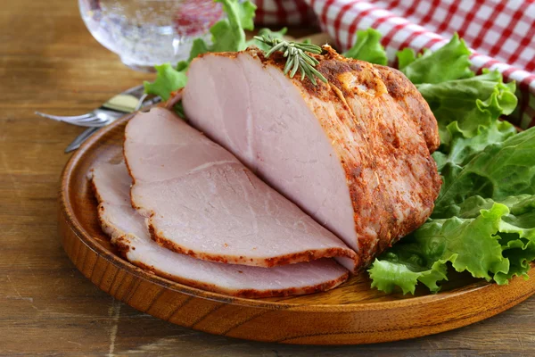 Roast pork with paprika and rosemary served on a wooden plate — Stock Photo, Image