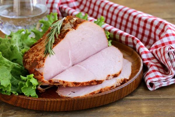 Roast pork with paprika and rosemary served on a wooden plate — Stock Photo, Image