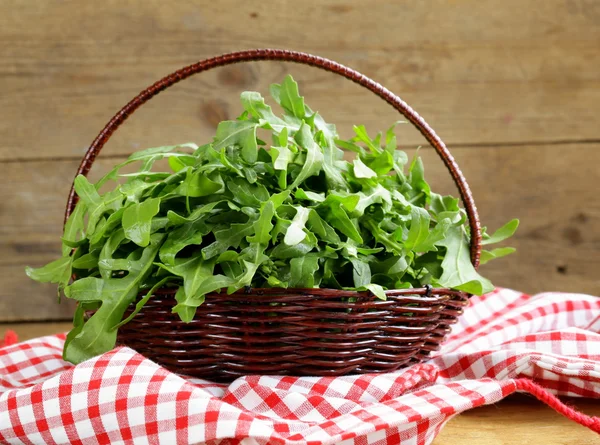 Grande mazzo di insalata verde rucola su un tavolo di legno — Foto Stock