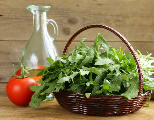 Large bunch of arugula green salad on a wooden table — Stock Photo, Image