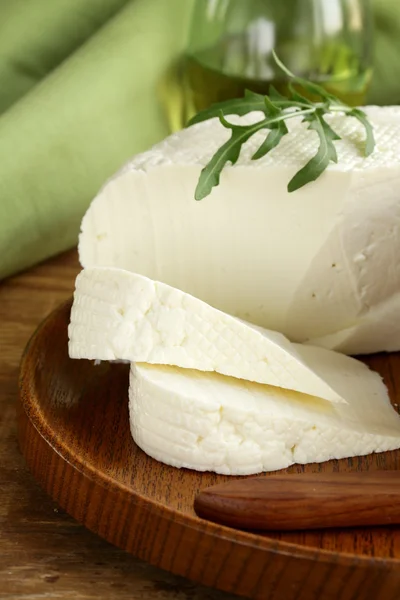 Salted milk cheese (feta cheese) on wooden plate — Stock Photo, Image