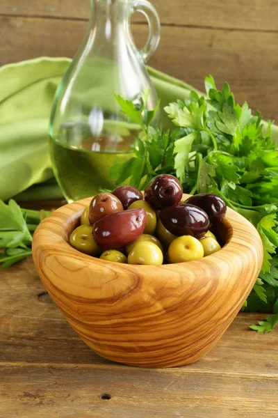 Gemarineerde groene en zwarte olijven (kalamata) in een houten kom — Stockfoto