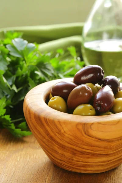 Olive marinate verdi e nere (Kalamata) in una ciotola di legno — Foto Stock