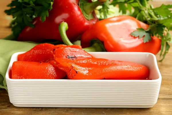 Grilled red bell pepper in a white bowl on wooden table — Stock Photo, Image