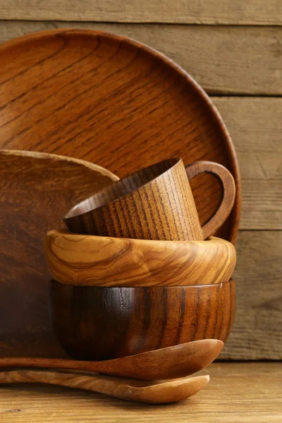 Комплект деревянной органической посуды на натуральном деревянном фоне — стоковое фото