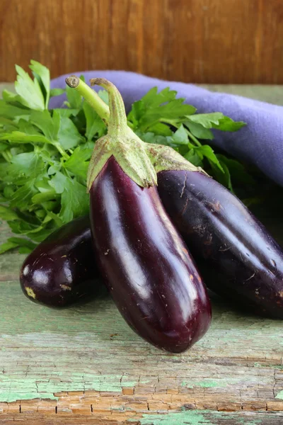 Reife lila Auberginen auf einem hölzernen Hintergrund — Stockfoto