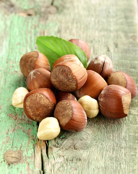 Haldy lískové ořechy (oříšky) na dřevěné pozadí — Stock fotografie