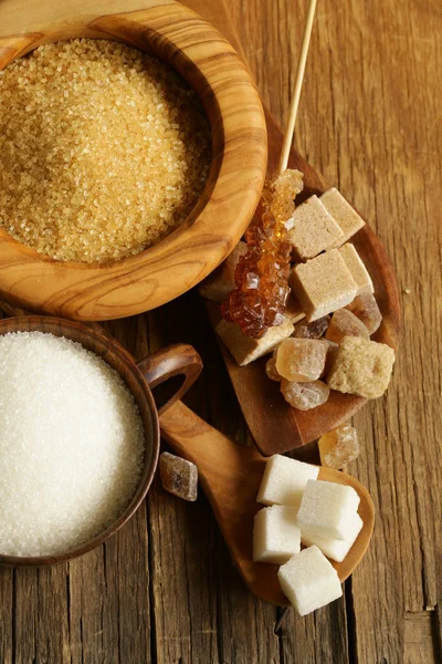 Различные виды сахара - коричневый, белый, рафинированный сахар на деревянном фоне — стоковое фото