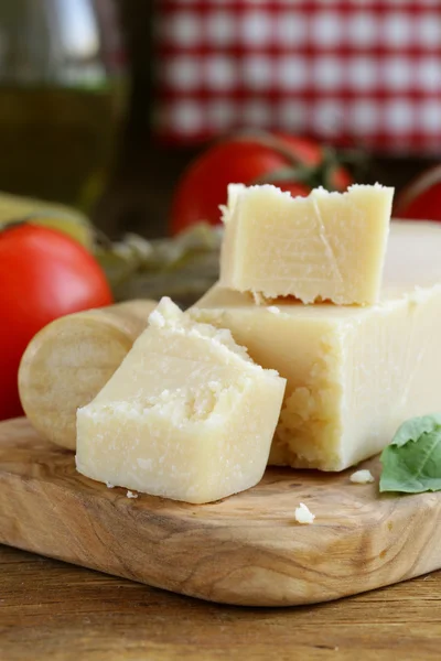 Stuk van natuurlijke Parmezaanse kaas op een houten bord — Stockfoto