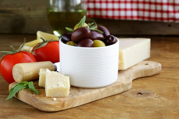 Olive, parmigiano, pomodori e basilico su un tavolo di legno — Foto Stock