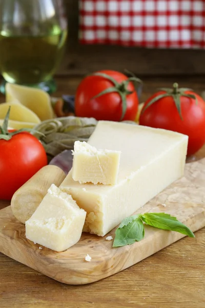 Pedazo de queso parmesano natural en una tabla de madera —  Fotos de Stock