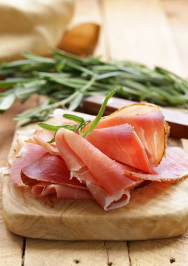 Parma jambonu (jamon) ahşap bir tahta üzerine dilimlenmiş