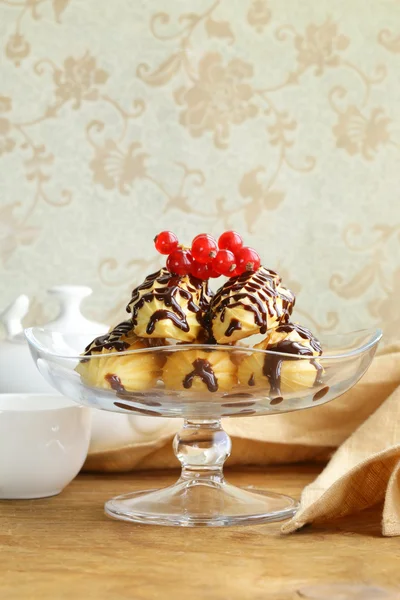 Choux pastelaria eclairs na base de suporte de vidro, sobremesa festiva — Fotografia de Stock