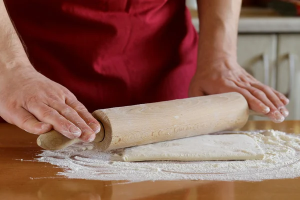 Hand man kock Matlagning degen på ett träbord — Stockfoto