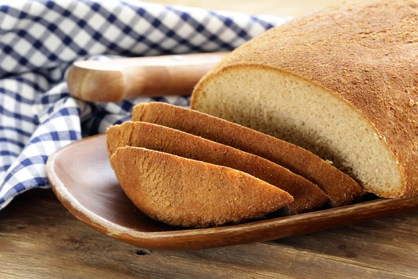 Loaf of rye bread on a wooden table — Stock Photo, Image