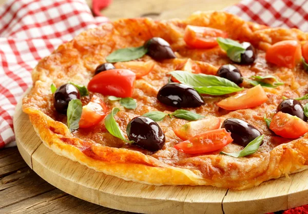 Italiaanse pizza met olijven en tomaten op houten bord — Stockfoto