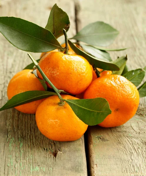 Verse rijpe oranje mandarijnen (tangerines) op een houten tafel — Stockfoto