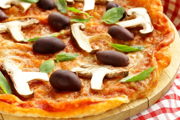 Italian pizza with olives and mushrooms on a wooden board — Stock Photo, Image