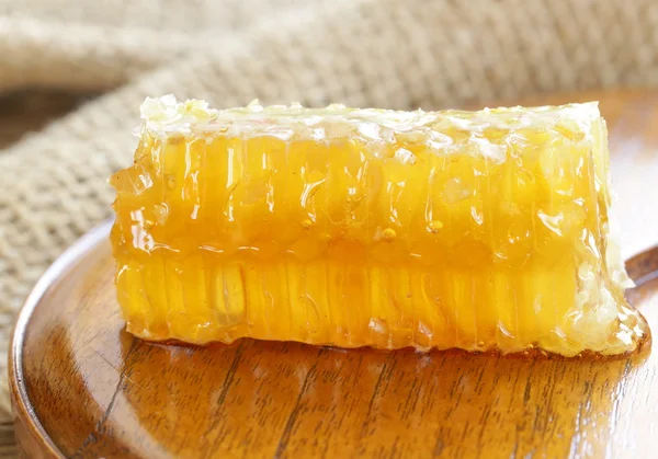 Naturliga organiska söta honeycomb på en träplatta — Stockfoto