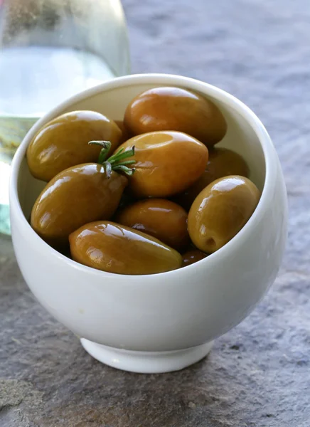 Green marinated olives in a white bowl — Stock Photo, Image