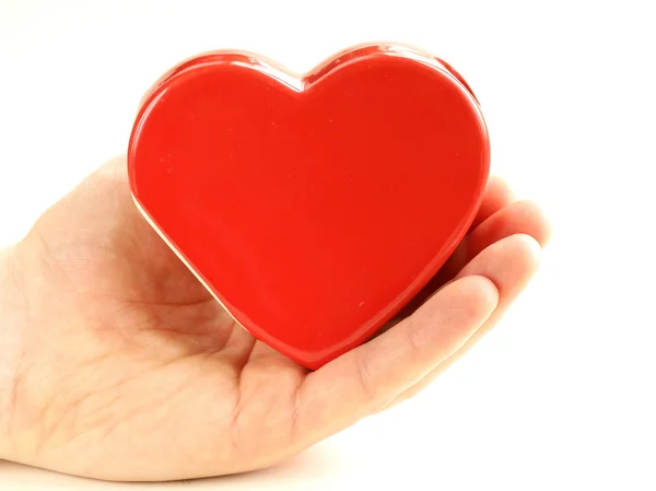 Corazón rojo cerámico en una mano masculina sobre un fondo blanco —  Fotos de Stock
