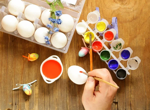 Coloring Easter eggs (hand in the shot) paint and brushes — Stock Photo, Image
