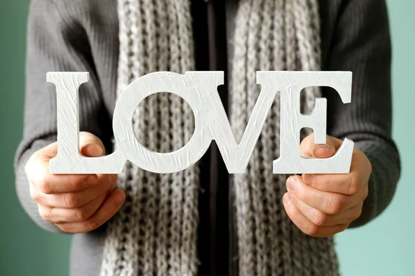 Man med trä ordet kärlek mjuk fokus på bokstäverna — Stockfoto